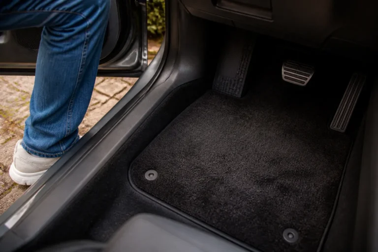 velours automat bij bestuurderspedalen terwijl bestuurder instapt in auto-interieur
